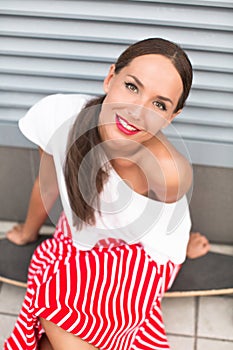 Hipster lady sitting on longboard