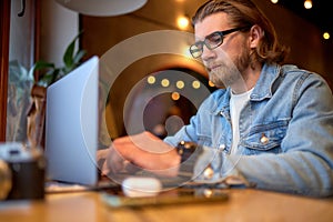 hipster lifestyle and creative workspace,confident guy working on laptop in coffee shop