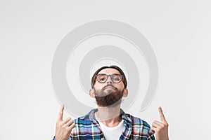 Hipster, lifestyle and people concept - Young hipster man point up on white background with copy space