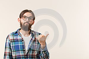 Hipster, lifestyle and people concept - Young hipster man point on white background with copy space