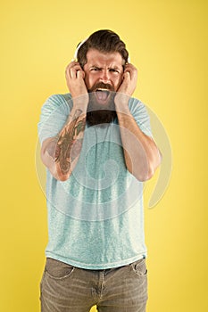 Hipster listen broken headphones music gadget. Hateful song. Music taste. Bearded guy dislike music. Irritating sound