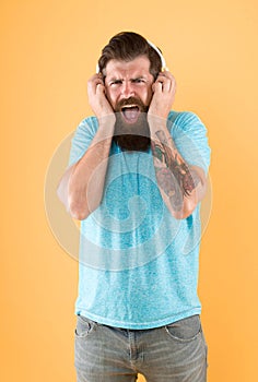 Hipster listen broken headphones music gadget. Hateful song. Music taste. Bearded guy dislike music. Irritating sound