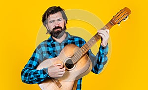 hipster with long hair and moustache sing a song. male guitarist with acoustic guitar. music concept. bearded man in