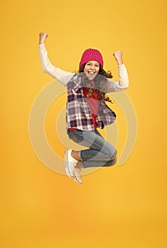 hipster look. cheerful child in knitted hat. denim fashion style. school girl on yellow background. full of energy. kid