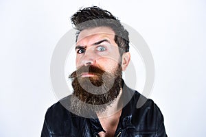 Hipster looks surprised and suspicious while raising his eyebrow. Masculinity concept. Man with beard and mustache on