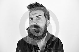 Hipster looks surprised and suspicious while raising his eyebrow. Masculinity concept. Man with beard and mustache on