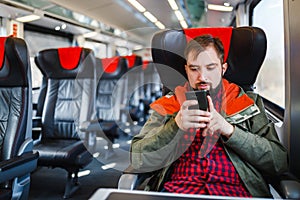 Hipster man with a beard is working with a smartphone, the concept of the wifi Internet and connection roaming in travel