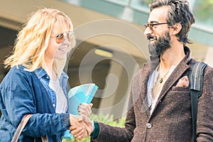 Hipster man and blond woman handshaking at informal business date