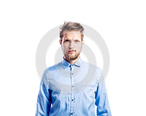 Hipster man in blue long-sleeved shirt, studio shot, isolated