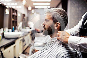 Hipster man client visiting haidresser and hairstylist in barber shop.