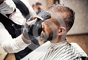 Hipster man client visiting haidresser and hairstylist in barber shop.