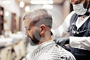 Hipster man client visiting haidresser and hairstylist in barber shop.