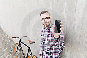 Hipster man in earphones with smartphone and bike