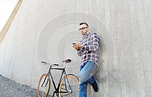 Hipster man in earphones with smartphone and bike