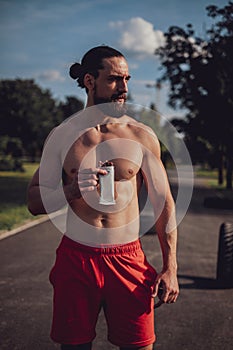 Hipster man eating protein bar after hard workout