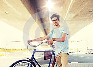 Hipster man with fixed gear bike under bridge