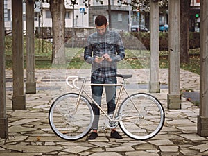Hipster man with a fixie bike and smartphone