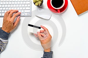 Hipster man hands holding a credit card and using laptop