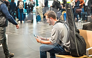 Hipster man at international airport using mobile smart phone