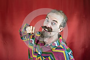 Hipster man with mustache threatening camera with his fist and shouting furious