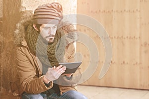 Hipster man sitting using tablet with a warm tone filter applied