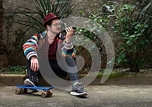 Hipster Man on Skateboard with Smartphone in Hand