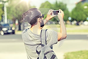 Hipster man taking picture on smartphone