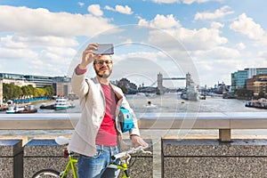 Hipster man taking a selfie in London while commuting