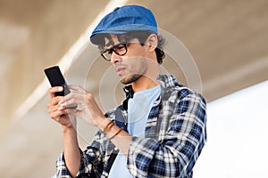 Hipster man texting message on smartphone