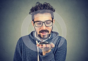 Hipster man using a smart phone voice recognition function