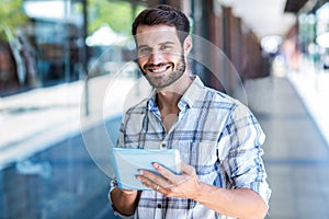Hipster man using tablet computer in the city
