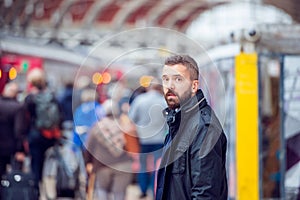 Hipster man waiting at the crowded train station