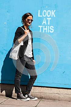 Hipster model wearing sunglasses posing next to Lo