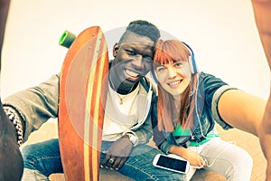 Hipster multiracial love couple taking urban fashion selfie