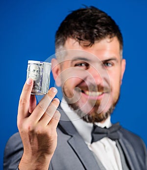 Hipster offer money blue background close up. Easy money concept. Rich businessman hold rolled money. Man bearded