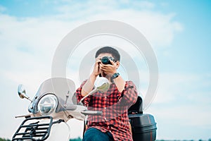 Photographer riding a motor scooter on road. Traveled by scooter slow life on vacation resting time