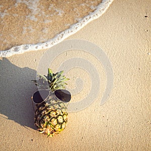 Hipster pineapple on beach - fashion in summer.