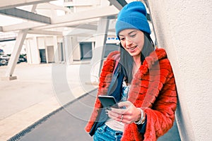 Hipster portrait of happy young woman with smartphone