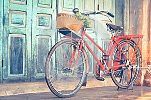 Hipster red bicycle in old building walls background