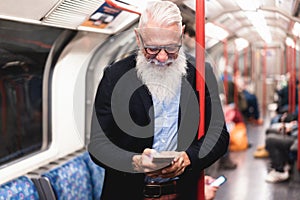 Hipster senior man chat messaging on mobile phone in subway train - Focus on face