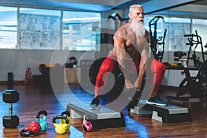 Hipster senior man training inside gym - Mature tattooed person having fun doing workout exercises in sport fitness club - Active