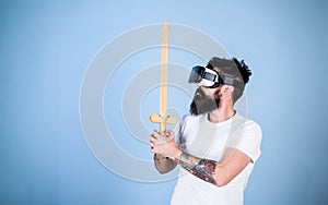 Hipster on serious face enjoy play game in virtual reality. Gamer concept. Man with beard in VR glasses, light blue