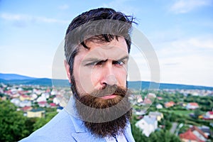 Hipster serious handsome attractive guy with long beard. Man bearded hipster with mustache blue sky background. Ultimate