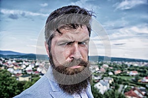 Hipster serious handsome attractive guy with long beard. Man bearded hipster with mustache blue sky background. Ultimate