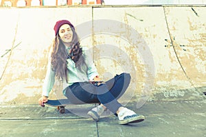 Hipster skateboarder girl with skateboard outdoor at skatepark