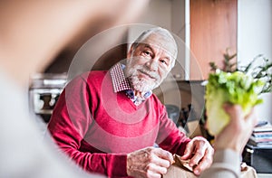 Hipster son with his senior father in the kitchen.