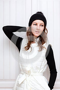 Hipster Style Brunette Girl Swag wearing Black fashion beanie knitted hat with bumbon pumpon. Season Fall Winter