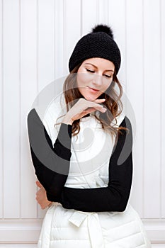 Hipster Style Brunette Girl Swag wearing Black fashion beanie knitted hat with bumbon pumpon. Season Fall Winter