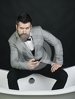 Hipster with stylish appearance in luxury old fashioned bathtub.