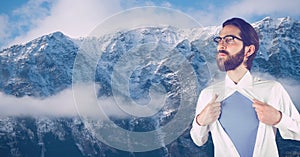 Hipster tearing shirt against snowcapped mountains